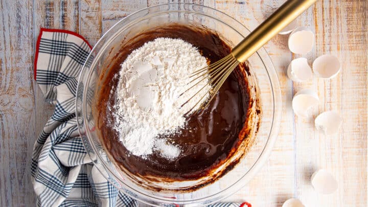 Adding dry ingredients to brownie batter.
