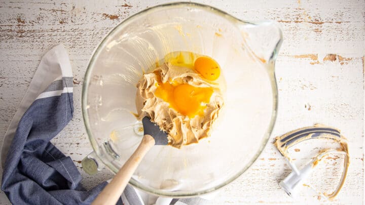 Adding eggs to peanut butter oatmeal cookie dough.