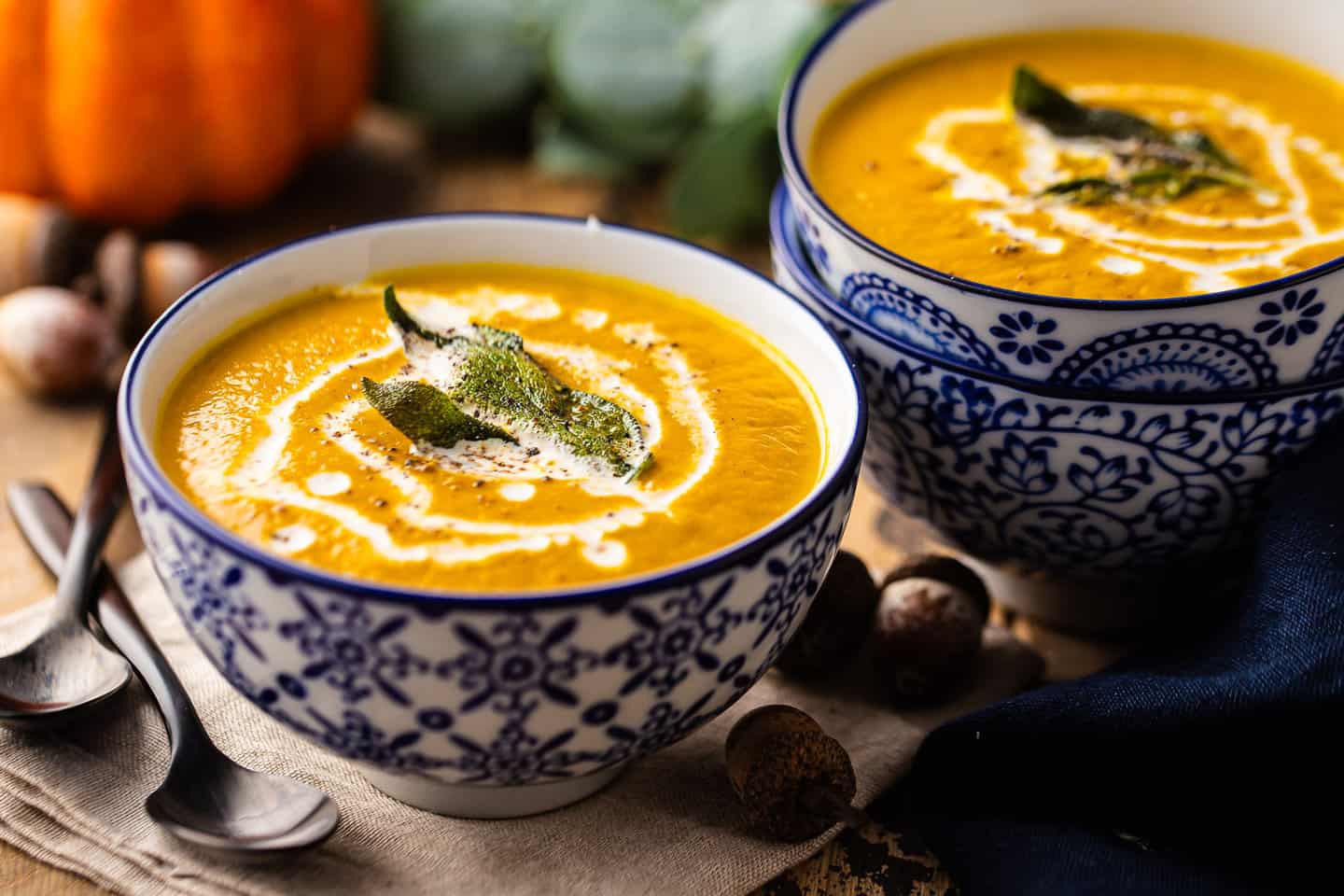Pumpkin soup recipes served in small blue bowls with crispy sage.