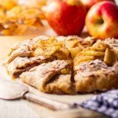 A freshly baked apple galette, served on a crumpled sheet of parchment.