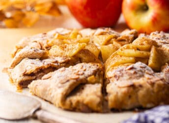 A freshly baked apple galette, served on a crumpled sheet of parchment.