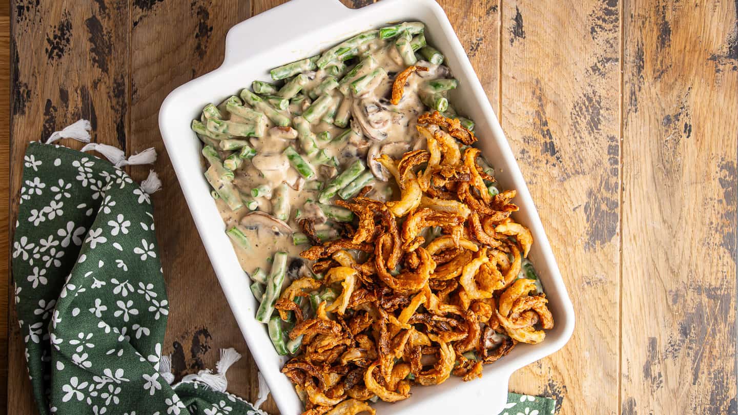 Layering homemade French-fried onions over green bean casserole.