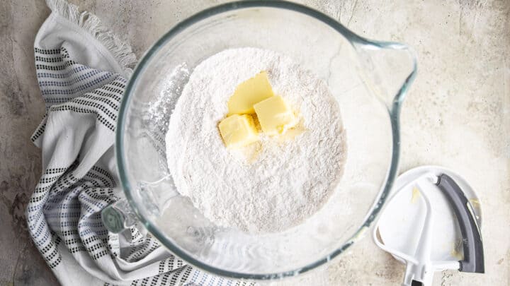 Adding soft butter to dry ingredients.