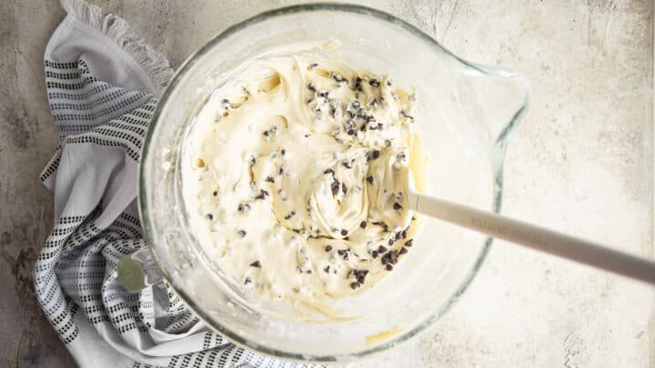 Chocolate chip cake batter in a large glass mixing bowl.