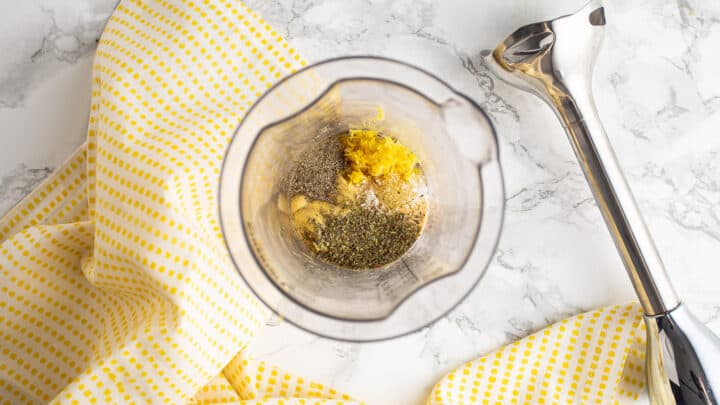 Honey, lemon zest, mustard, and seasonings in the cup of a hand blender.