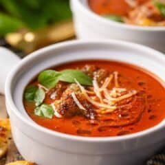 Easy tomato soup recipe, prepared and served in white crocks.