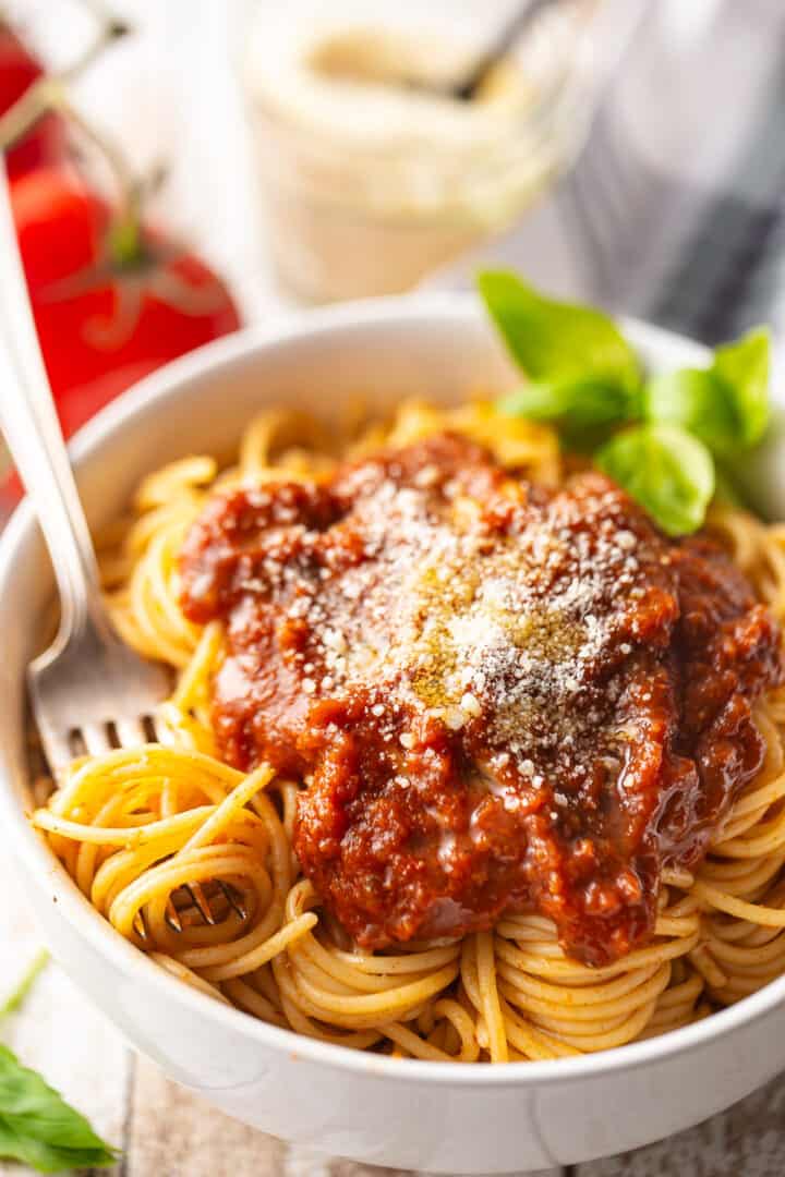 Homemade tomato sauce, served over cooked spaghetti with fresh basil and parmesan cheese.
