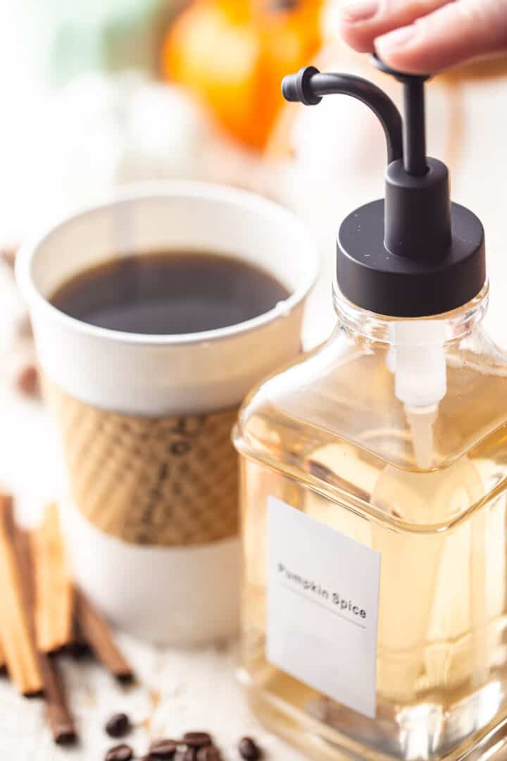 Pumpkin pumpkin spice coffee syrup into a to-go cup of black coffee.