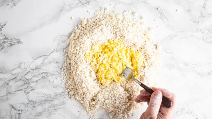 Incorporating egg into gnocchi dough.