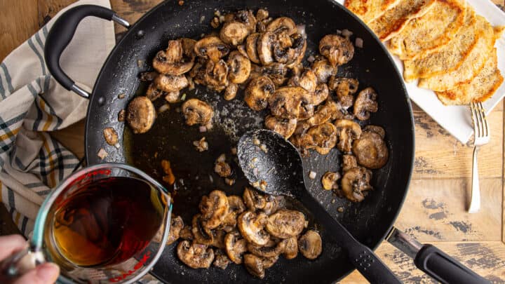Slowly whisking marsala wine into mushrooms, shallots, and roux.