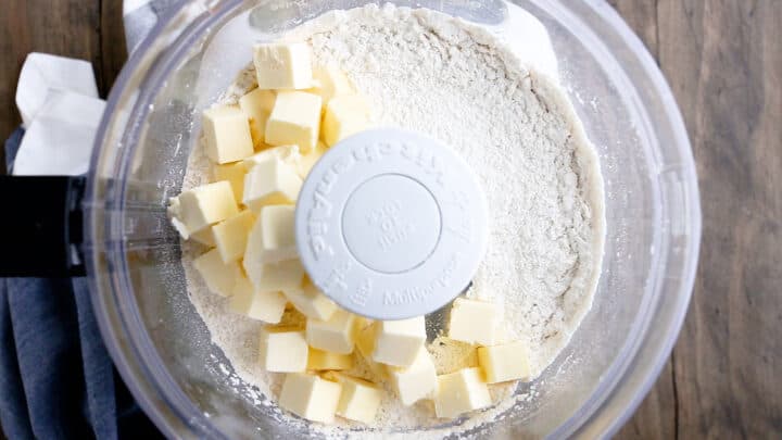 Adding cold, cubed butter to dry ingredients.