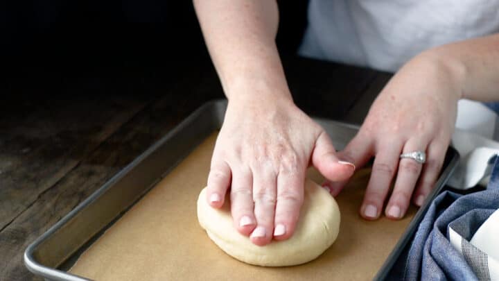 Flattening scone dough into a disc shape.
