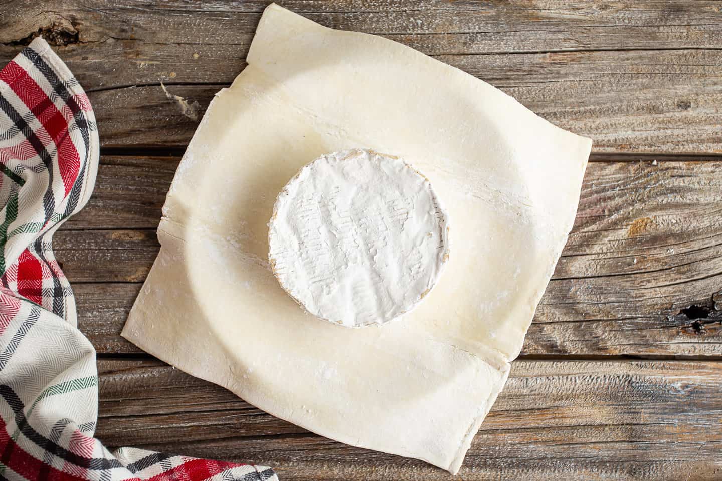 Wheel of brie on a sheet of puff pastry.