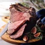 Standing rib roast, sliced and presented on a wooden carving board.