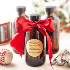 Vanilla extract in amber glass bottles with a red satin ribbon.