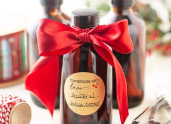 Vanilla extract in amber glass bottles with a red satin ribbon.