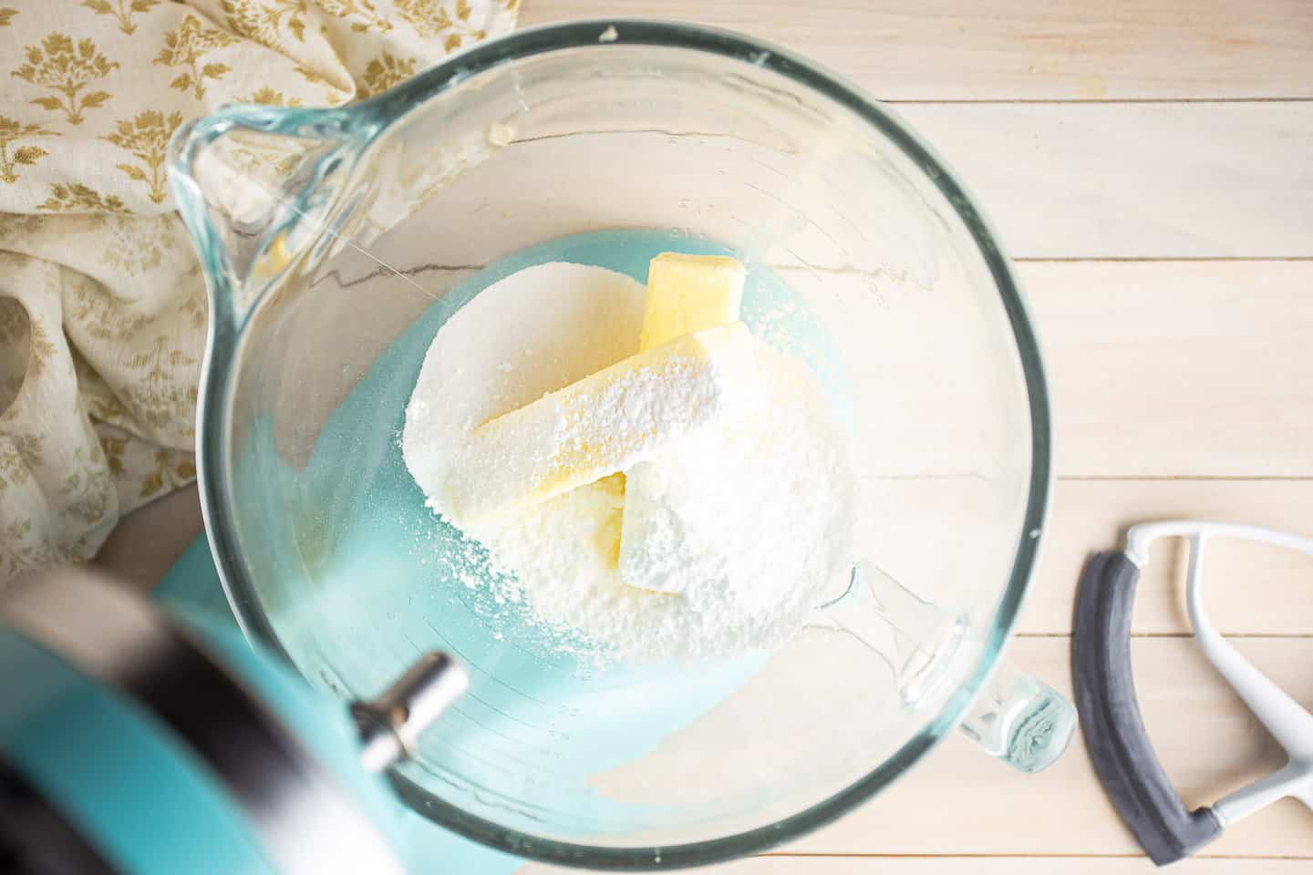 Butter, sugar, and powdered sugar in a large glass mixing bowl.