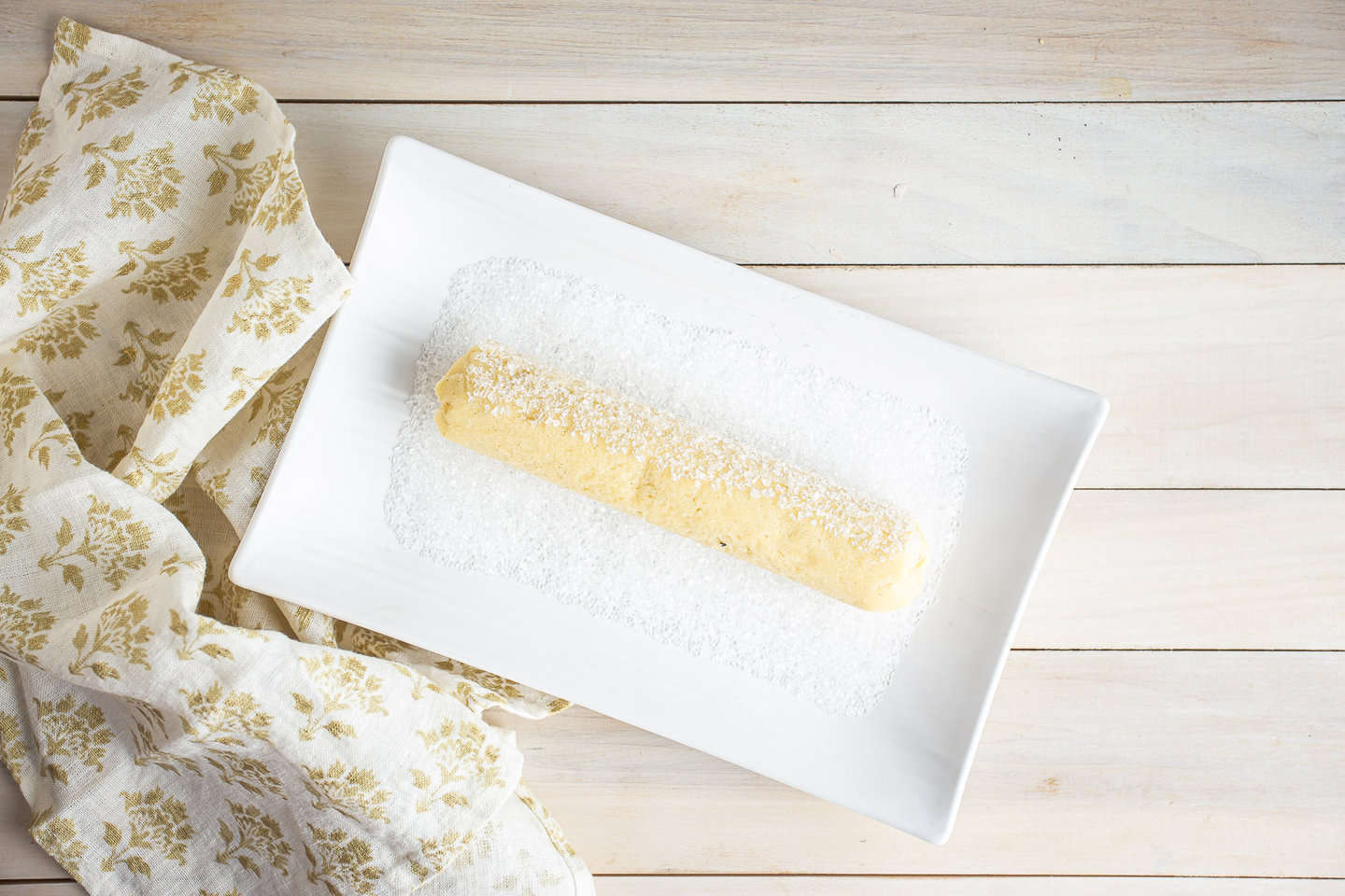 Rolling butter cookies in sparkling sugar.
