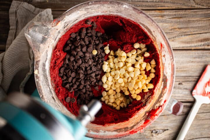 Adding chips to red velvet chocolate chip cookie dough.