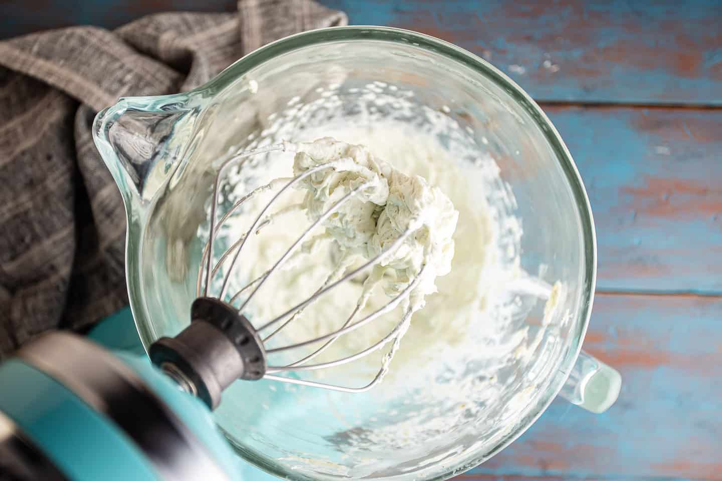 Whipped blue cheese dip in a stand mixer fitted with the whisk attachment.
