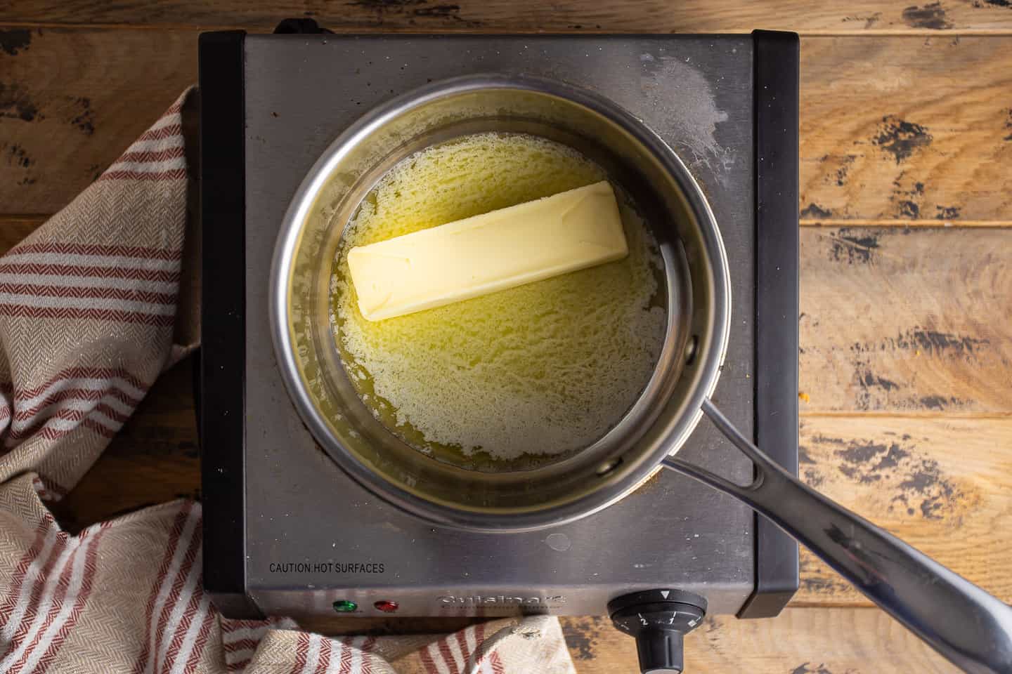 Melting butter in a small stainless steel pot.