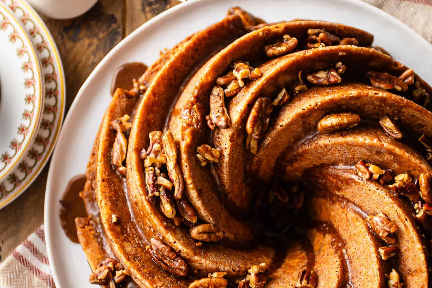 Recipe for rum cake, prepared in a bundt pan and topped with glaze and toasted nuts.