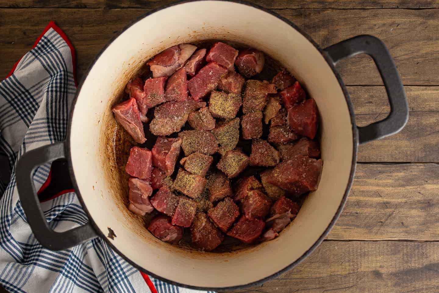 Seasoned beef cubes in a large pot.