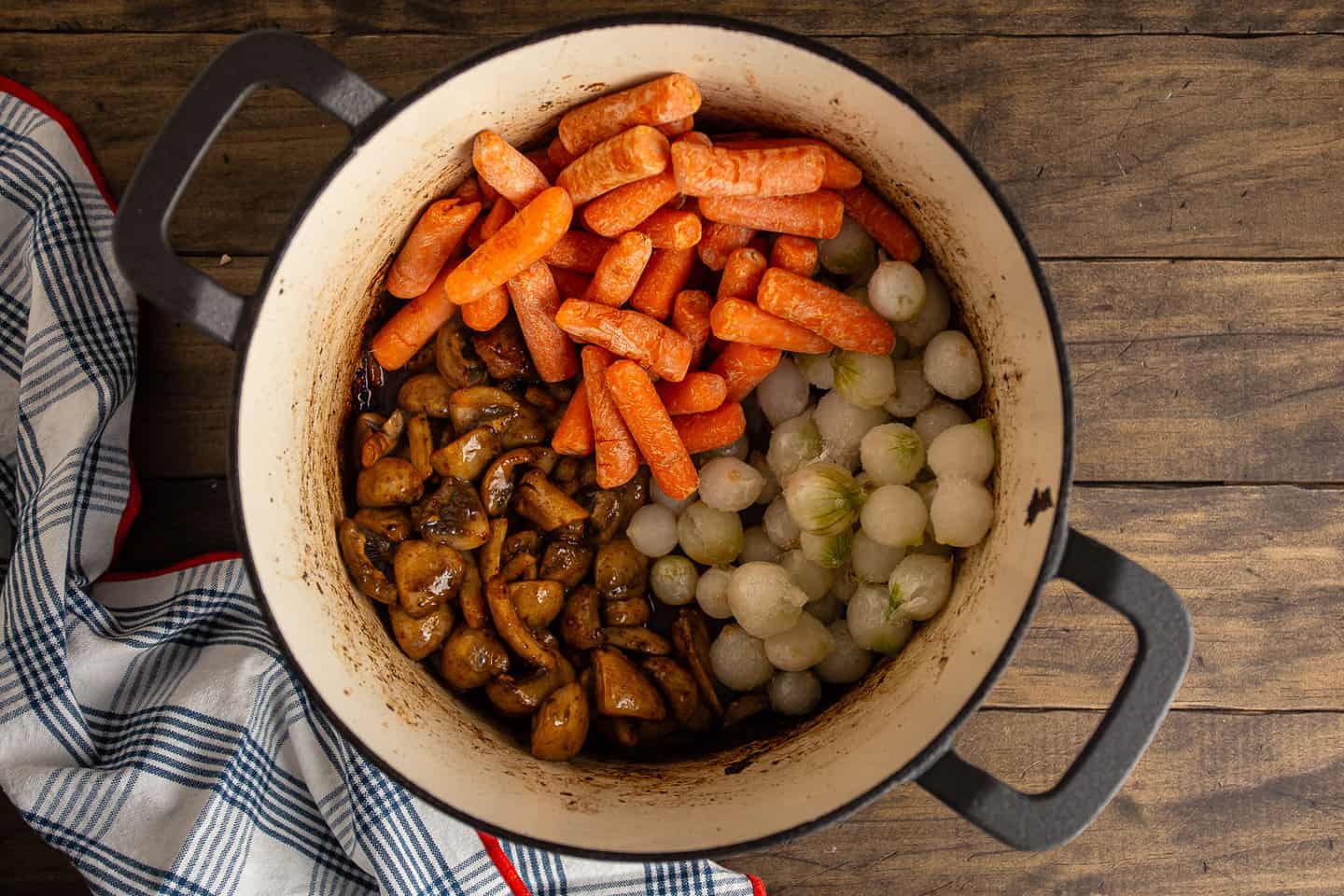 Sauteeing mushrooms, carrots, and pearl onions.