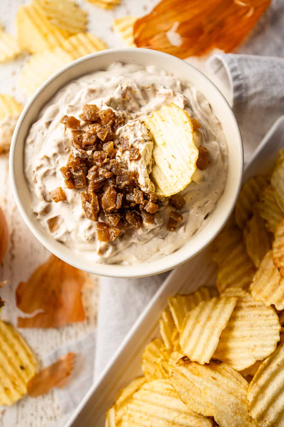 Onion dip with a chip dipping into it.