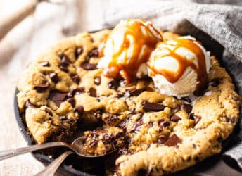 Skillet cookie with ice cream and two spoons.