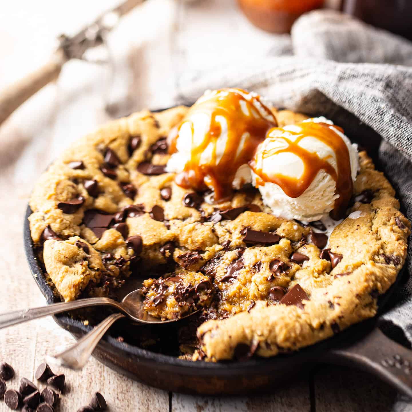 Skillet cookie with ice cream and two spoons.