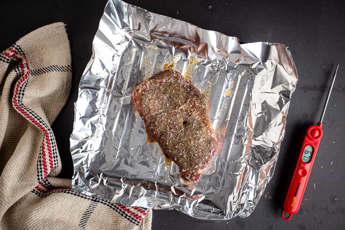 A seasoned steak that's been partially cooked in a low oven.