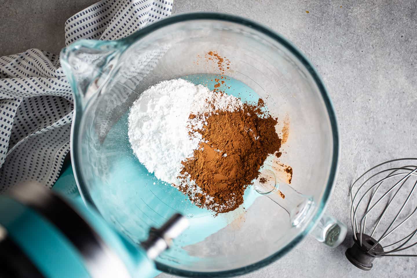 Powdered sugar and cocoa powder in the bowl of a stand mixer.