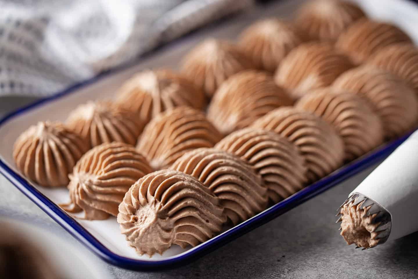 Chocolate icing using whipping cream, prepared and piped onto a tray with a French star tip.