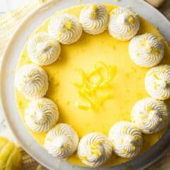 Lemon cheesecake with swirls of whipped cream and lemon zest.