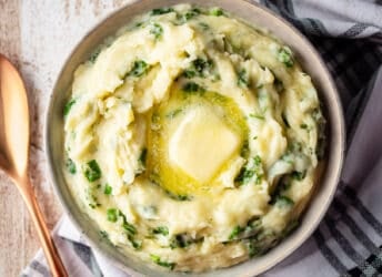 Colcannon in a serving bowl with butter melting on top.