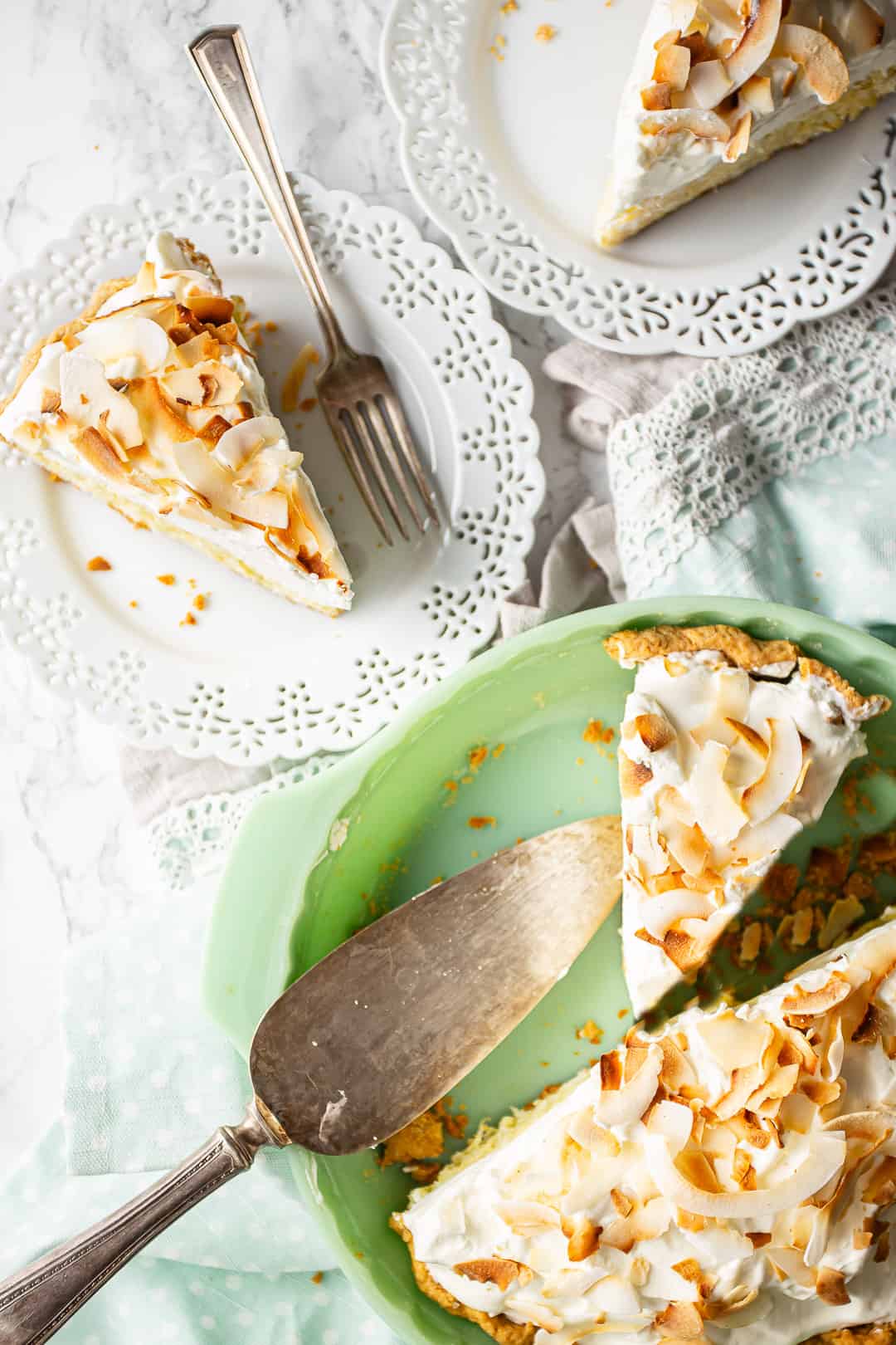 Coconut cream pie being served on white plates.