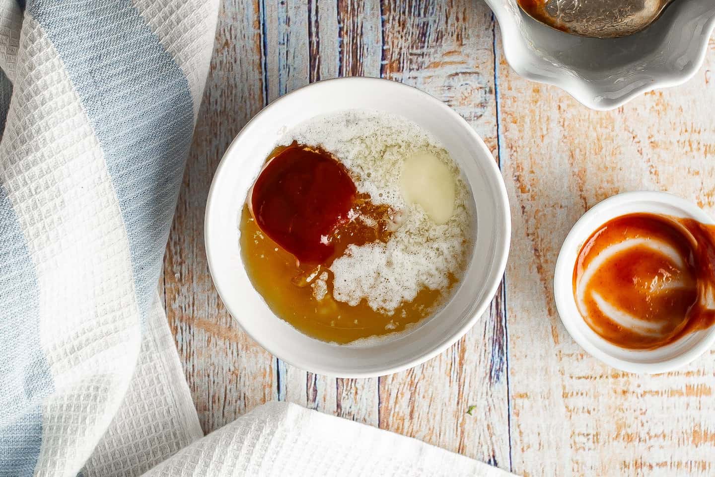 Melted butter, orange marmalade and sriracha sauce in a small bowl.