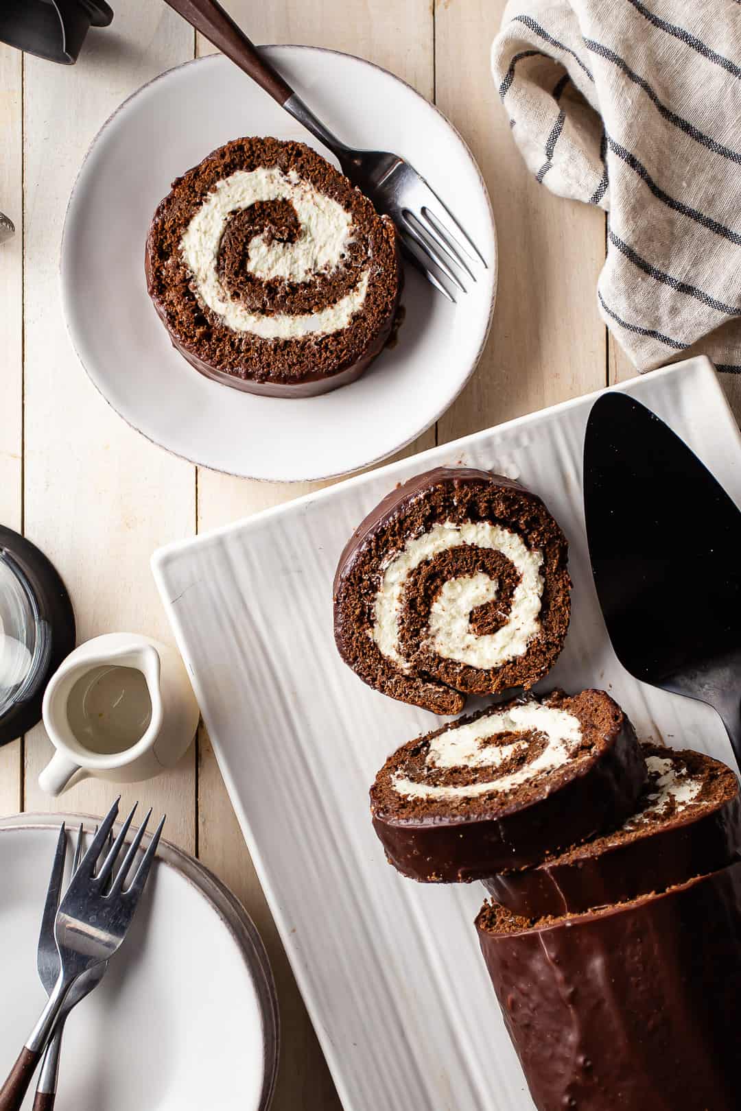Swiss roll cake recipe, prepared, sliced, and presented on white plates.