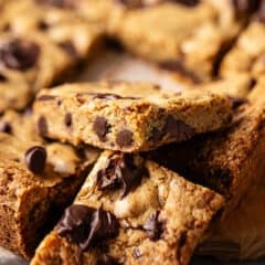 Chocolate chip blondies in a pile with crinkly tops and melted chocolate.