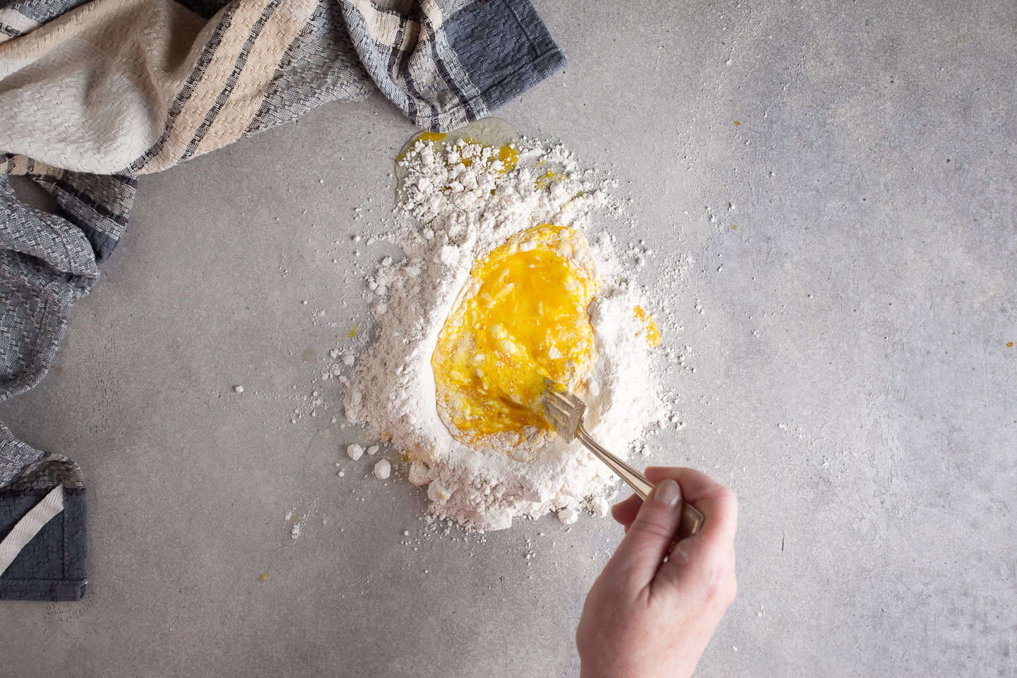 Whisking eggs into flour to make a dough.