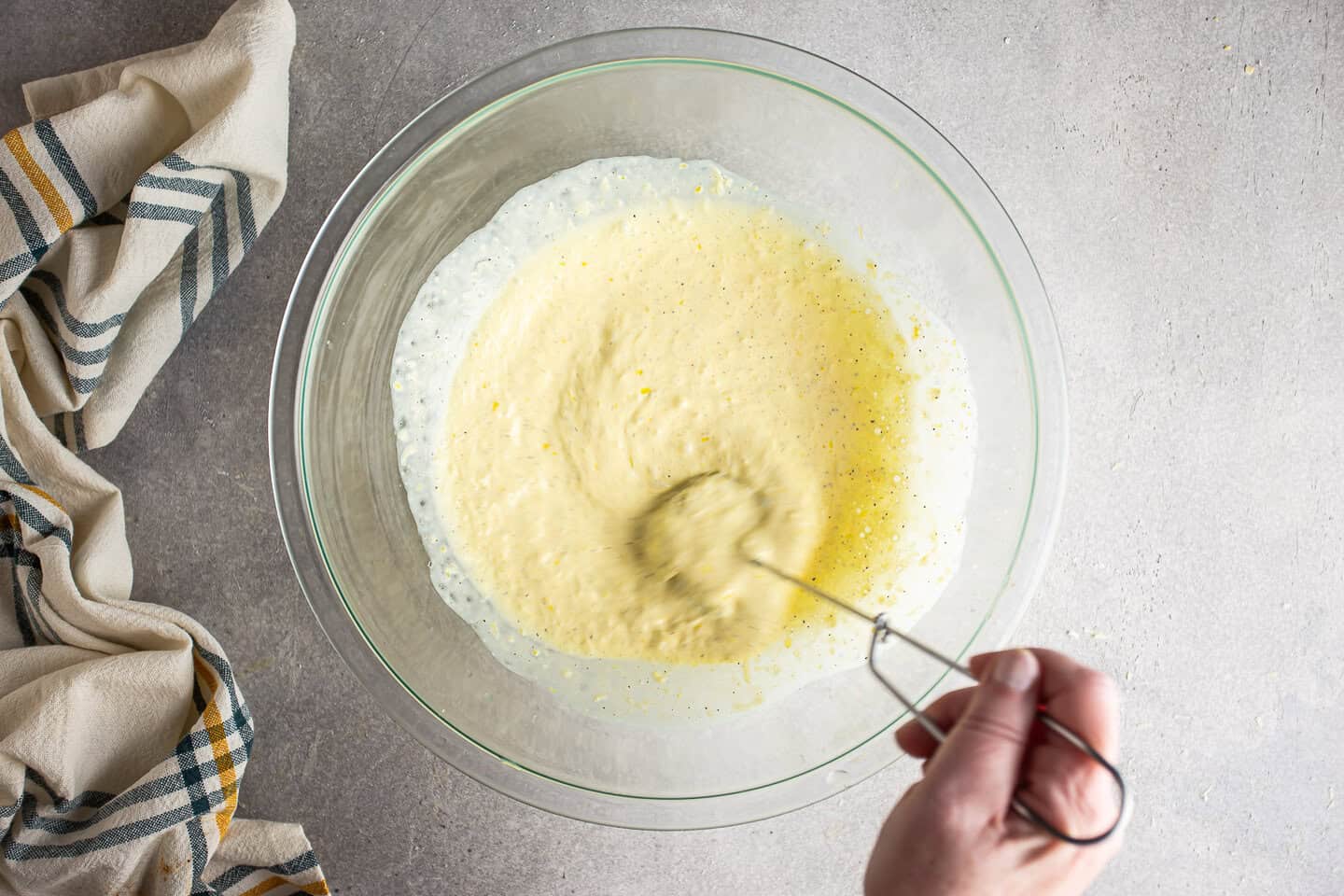 Whisking lemon pasta sauce together in a large mixing bowl.