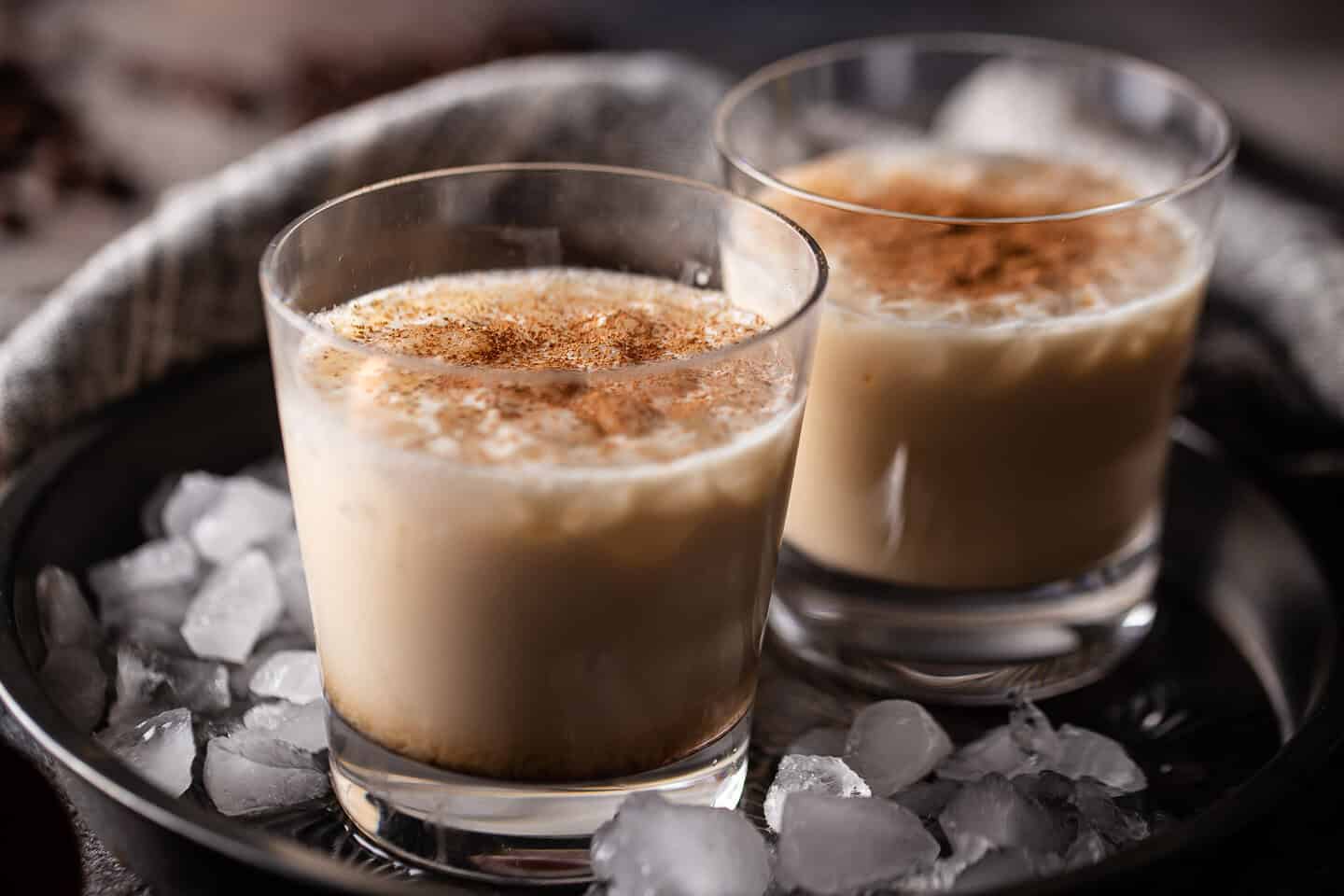 White Russian drinks presented in a vintage cake pan with crushed ice.