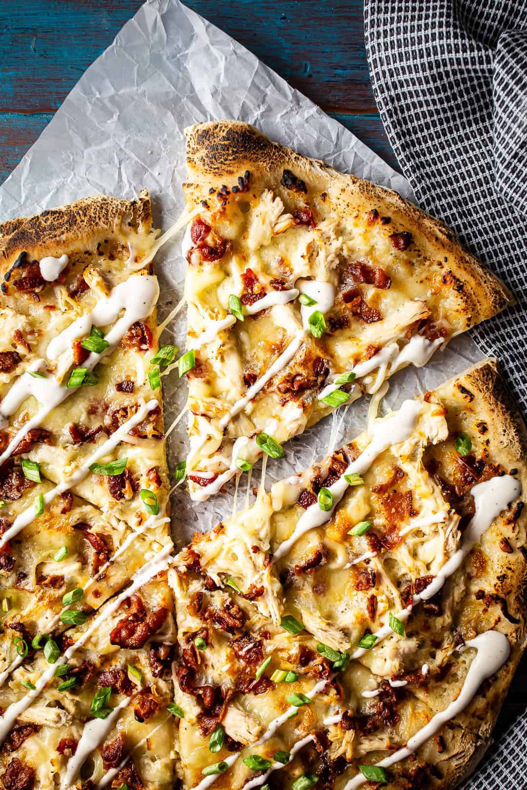 Bacon chicken ranch pizza baked and topped with a drizzle of creamy ranch dressing.