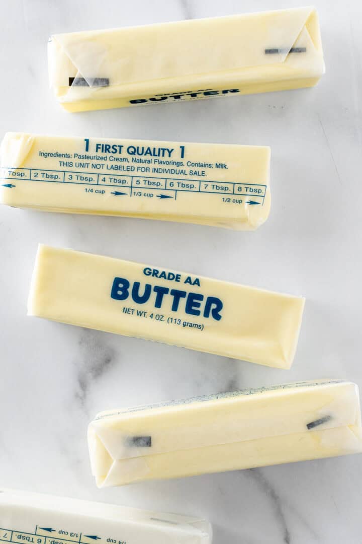 setting out five sticks of butter on white counter to soften butter.