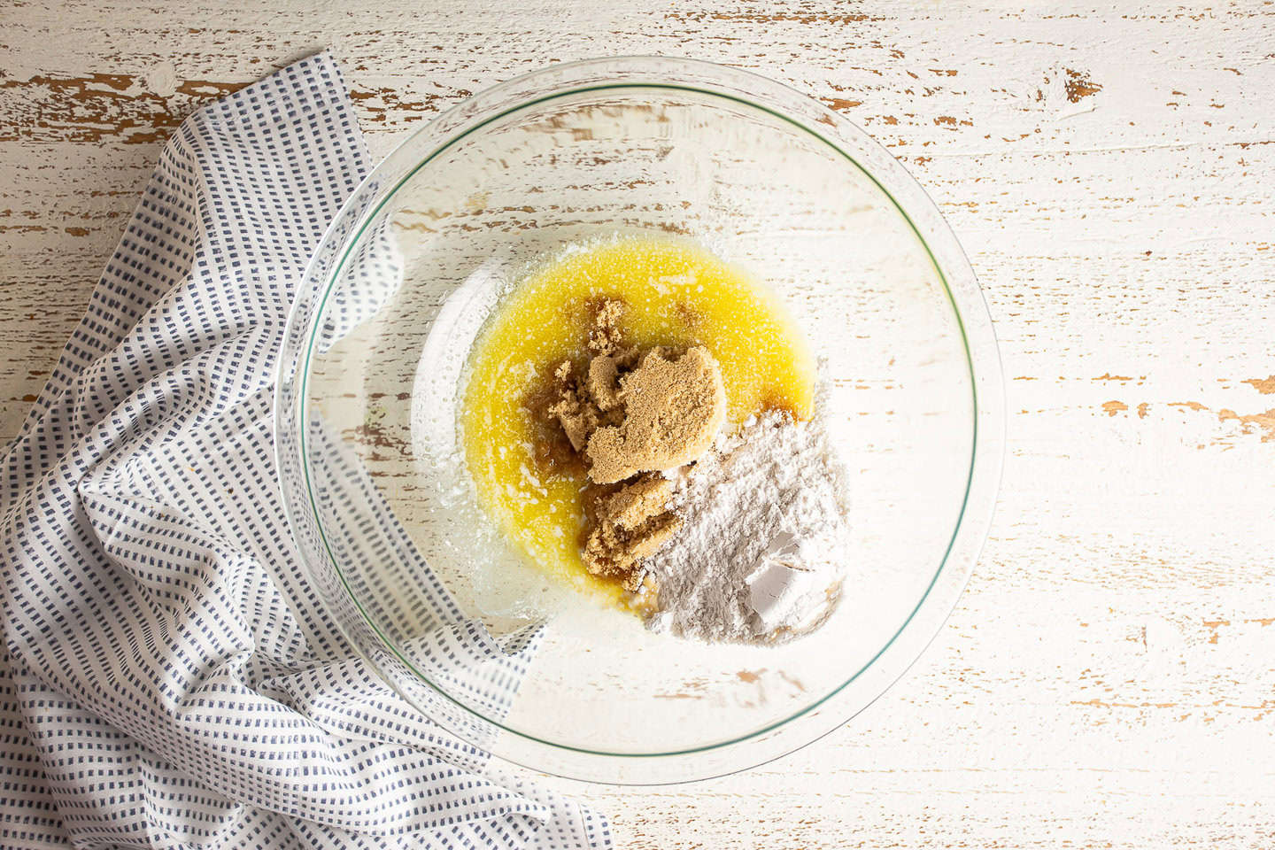 Melted butter, light brown sugar, and flour in a large glass mixing bowl.