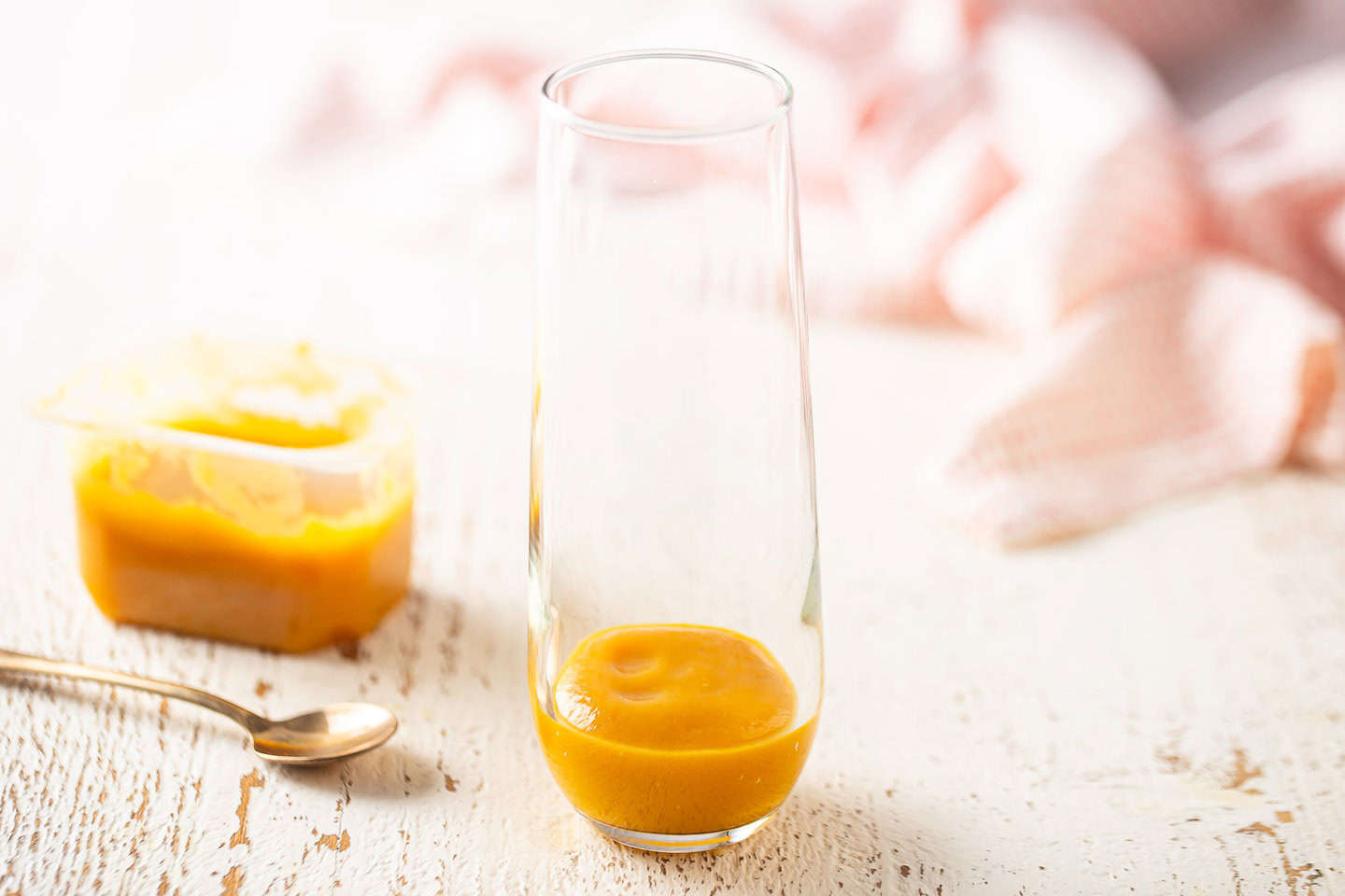 Peach puree in the bottom of a champagne flute.