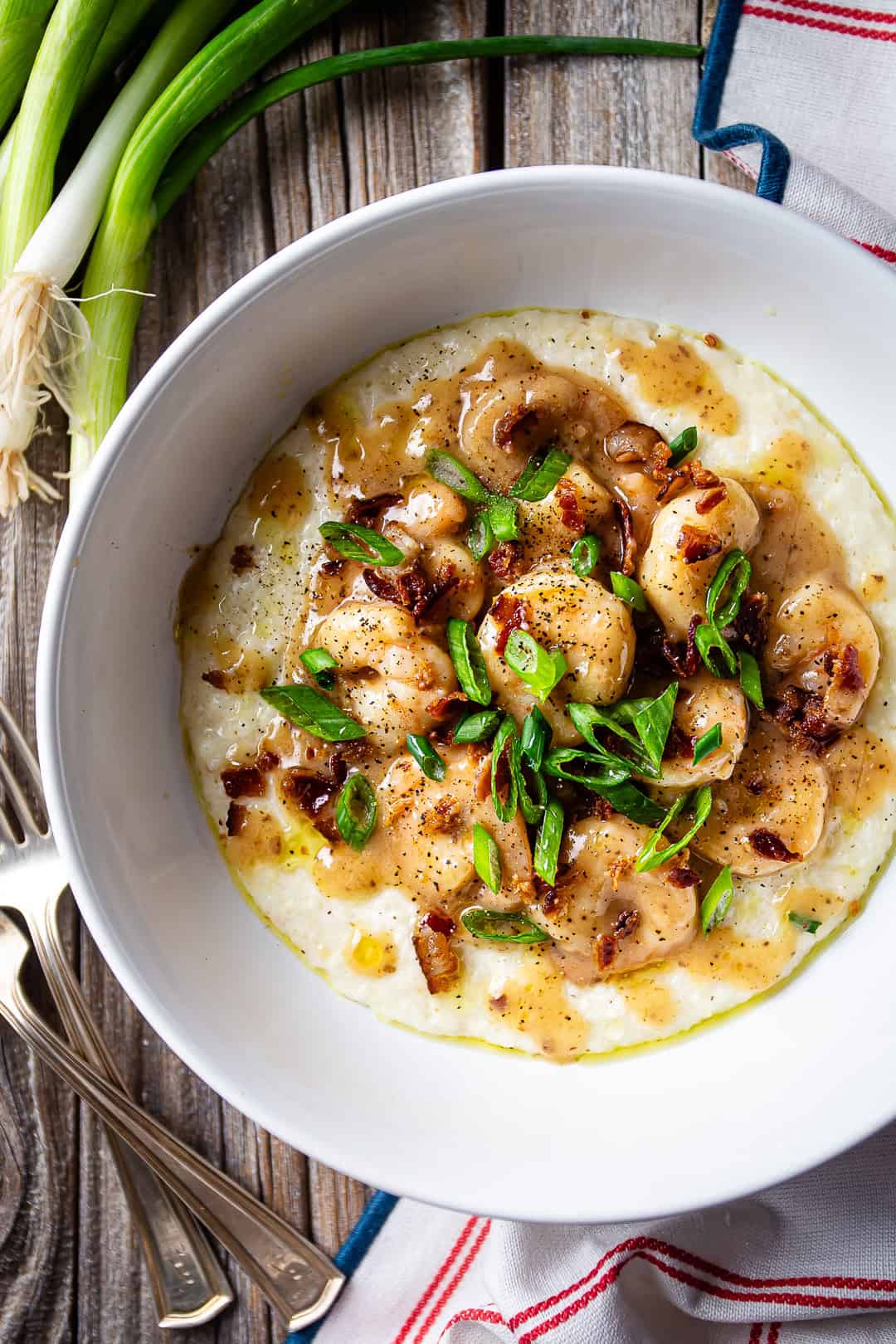 Recipe for shrimp and grits, cooked and served in bowls with green onions.