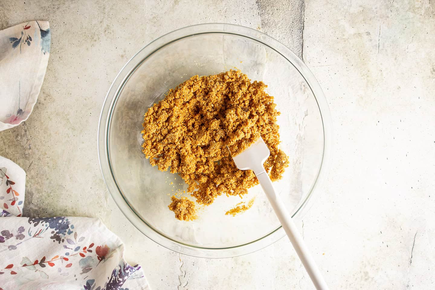 Mixing up Graham cracker crust in a large glass bowl.