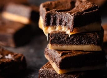 Salted caramel brownies stacked on top of one another.